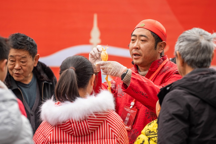 市民正在觀看“吹糖人”技藝展示。羅大富攝