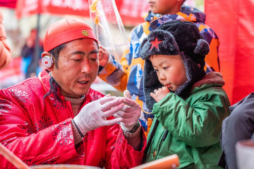 小朋友現場體驗“吹糖人”技藝。羅大富攝