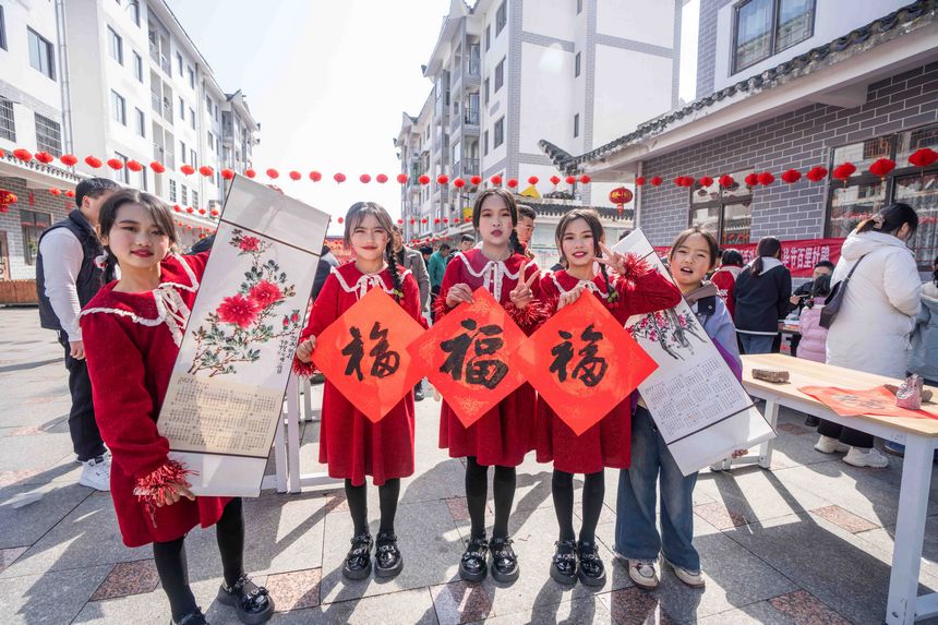 小朋友們展示現場領取的春節字畫。羅大富攝