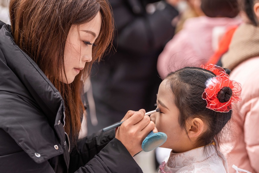 社區居民在給即將上臺表演的小朋友化妝。羅大富攝