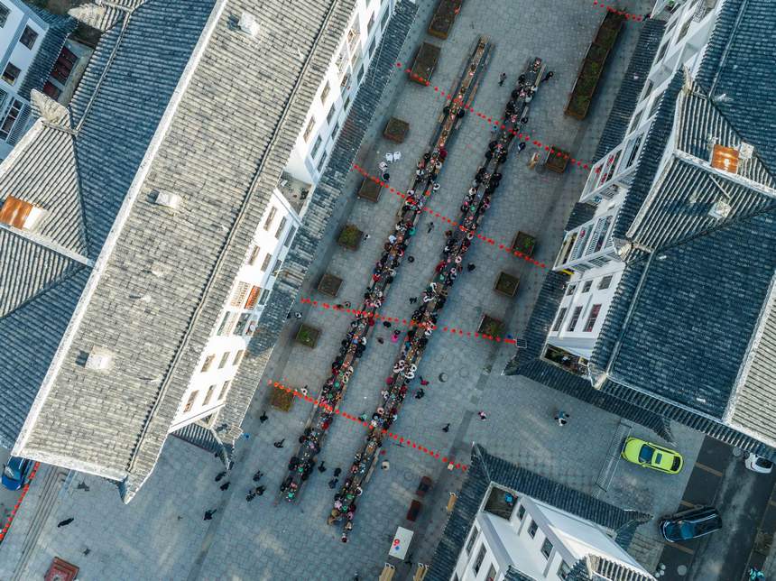 活動現(xiàn)場，社區(qū)群眾在共享長桌團圓飯。羅大富攝