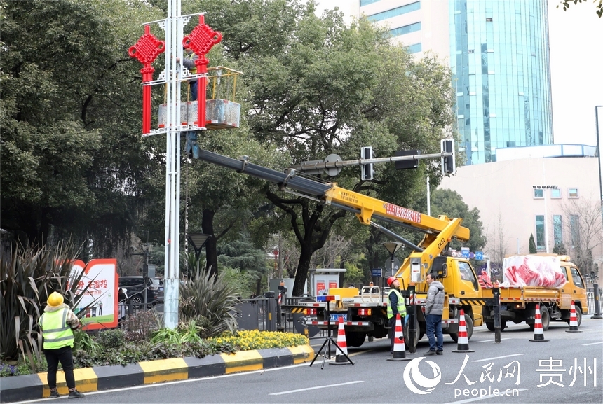 工人在主干道懸掛中國結。人民網 顧蘭云攝