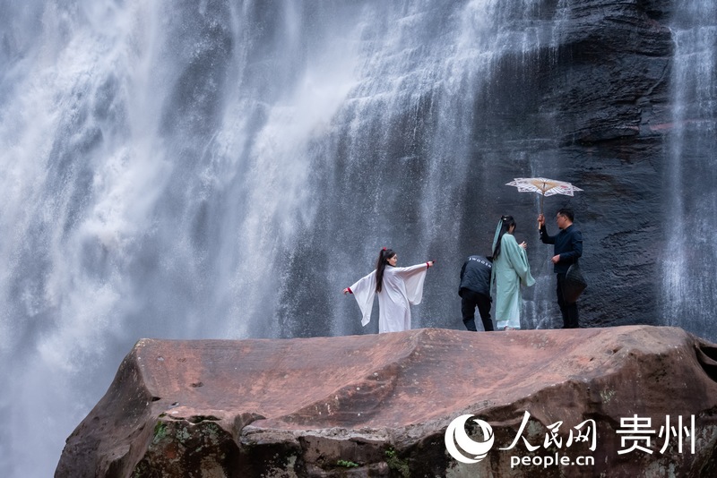 游客在赤水大瀑布前打卡拍照。人民網記者 涂敏攝
