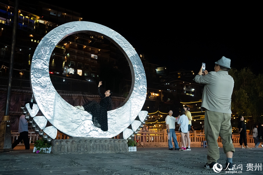 游客在西江苗寨內打卡拍照。人民網記者 涂敏攝