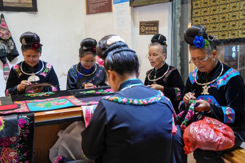 身穿苗族服飾的繡娘們圍坐在一起，手中針線翻飛，一幅幅精美的苗繡圖案在她們的巧手下逐漸成形。姚晶權攝