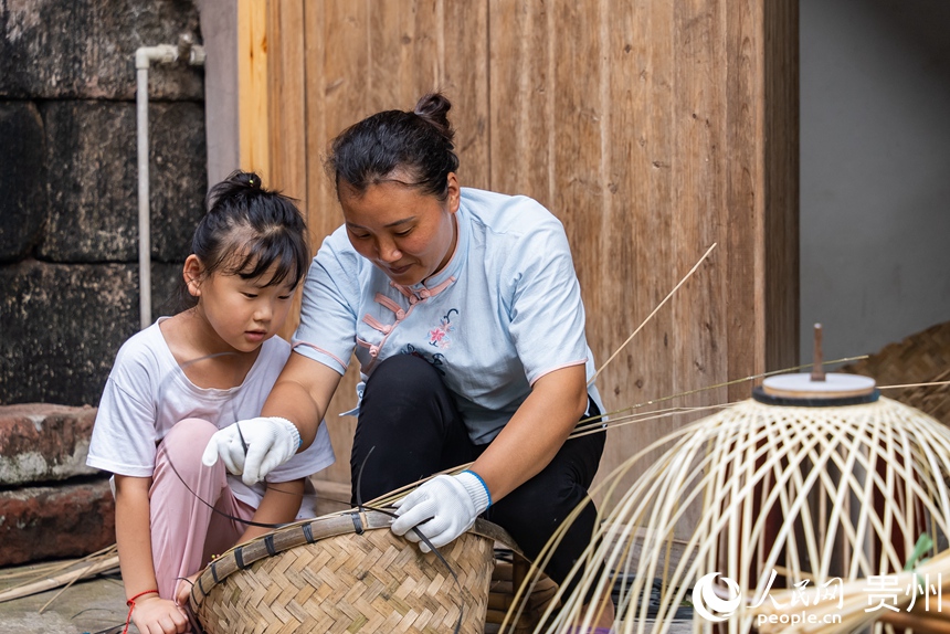 小朋友跟著媽媽學(xué)習(xí)竹編技藝。人民網(wǎng)記者 涂敏攝