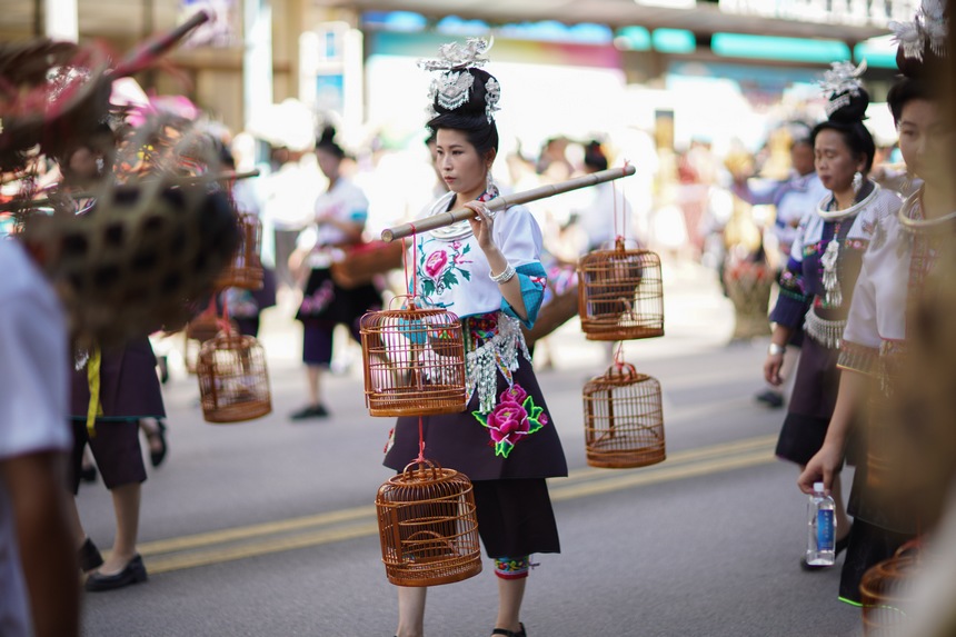7月21日,貴州省丹寨縣身著傳統盛裝服飾的群眾,在展示非遺項目鳥籠制作技藝作品。