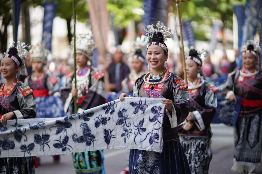 7月21日,貴州省丹寨縣身著傳統盛裝服飾的群眾,在展示國家級非遺項目苗族蠟染作品。