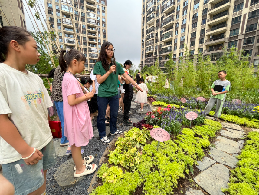 科普志愿者帶領(lǐng)居民參觀社區(qū)科普植物園。