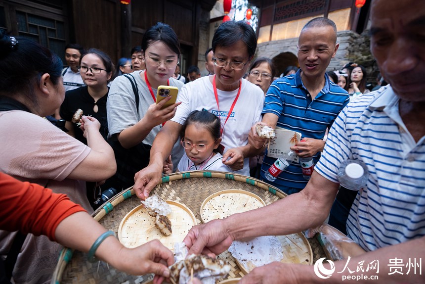 屯堡內，游客品嘗當?shù)靥厣亵巍Ｈ嗣窬W(wǎng)記者 涂敏攝