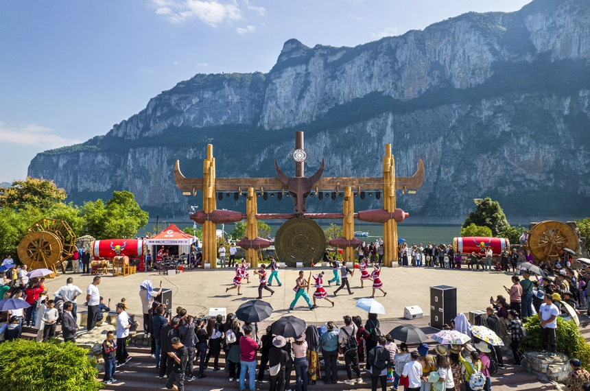 貴州省黔西市烏江源百里畫廊化屋景區，游客觀賞當地苗族村民表演原生態歌舞（無人機照片）。