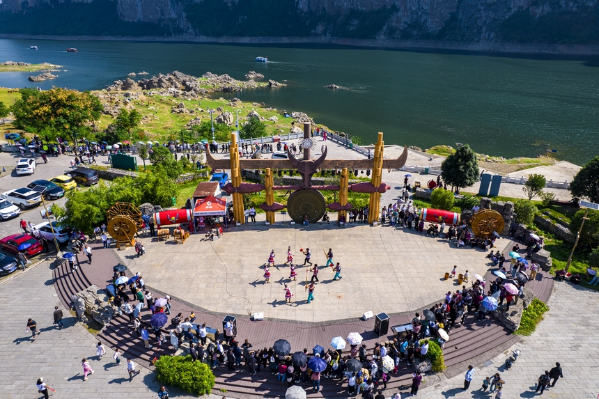 貴州省黔西市烏江源百里畫廊化屋景區，游客觀賞當地苗族村民表演原生態歌舞（無人機照片）。