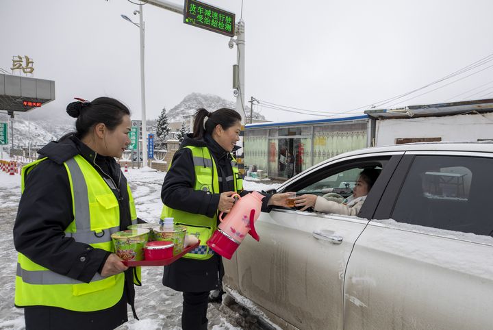 1月9日，畢威高速阿維寨站員工向司乘人員發放簡餐。李學友 攝.jpg