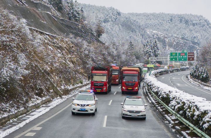 1月9日，警車壓速帶道滯留車輛駛離解除臨時交通管制的S20畢威高速公路。李學友攝