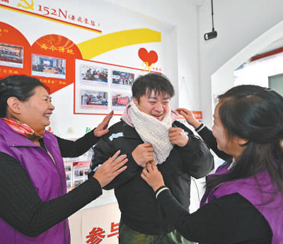 天津市河北區望海樓街道昆云里社區依托工會驛站,組織志愿者為新就業群體編織圍巾。