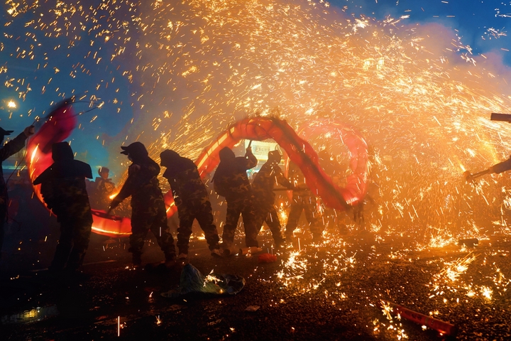 舞龍者在煙火中飛舞。