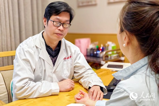 中醫(yī)館里，一名中醫(yī)正在把脈問(wèn)診。人民網(wǎng) 程明輝攝