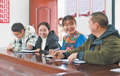 盧丹(右二)在致富村村委會(huì)和同事交流工作。