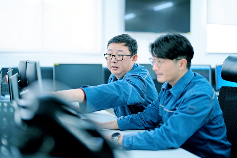 周敬余(左)給新員工講解監(jiān)控信號的作用。陳濤攝