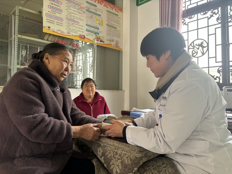 謝厚芝在給村民看病。