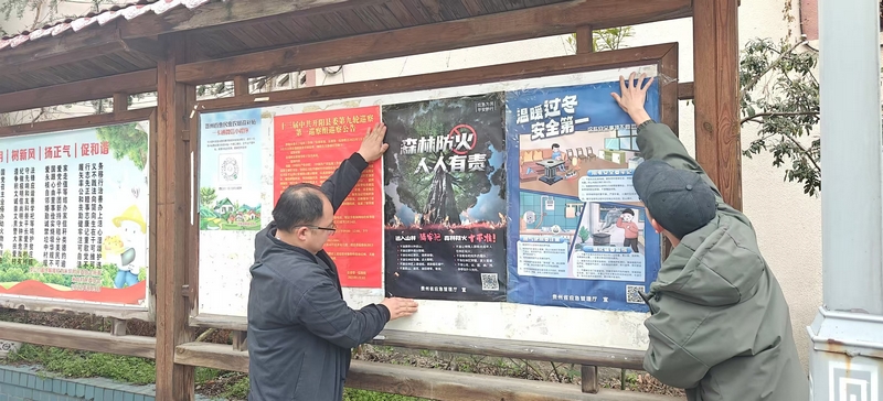 工作人員張貼森林防火相關海報 。吳小龍攝