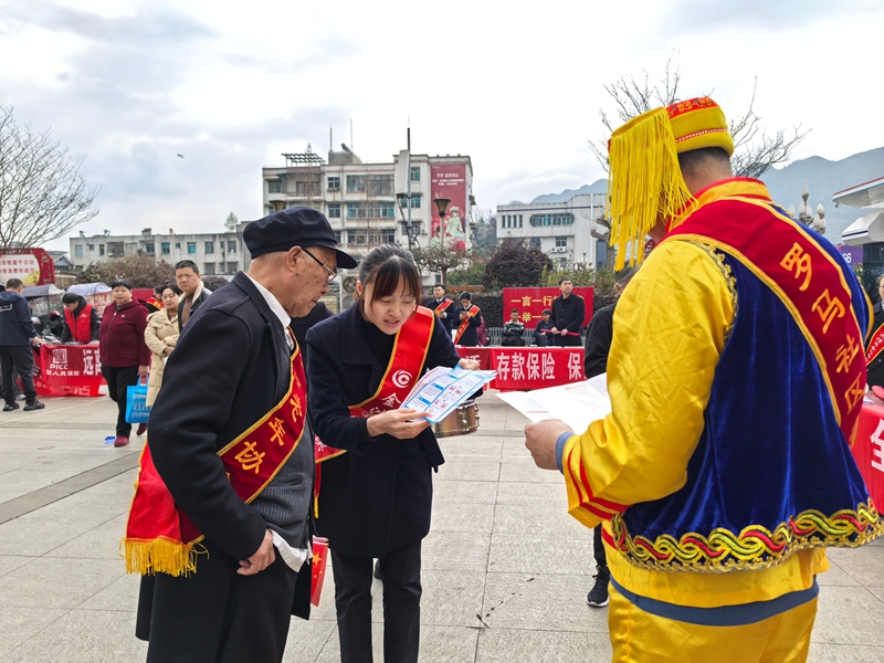 工作人員們向群眾講解電信網(wǎng)絡(luò)詐騙相關(guān)知識。