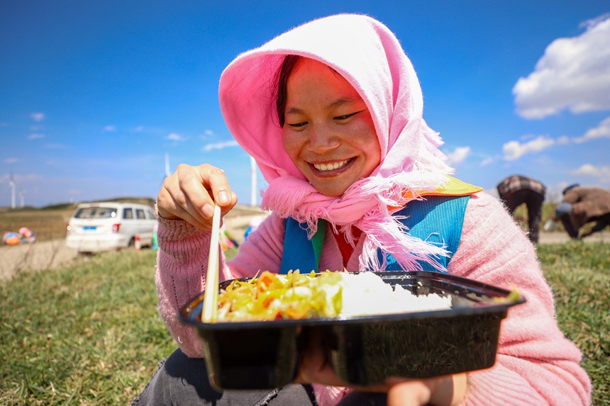務工群眾在威寧自治縣雪山鎮大發村畫眉梁子馬鈴薯種植基地吃午餐。