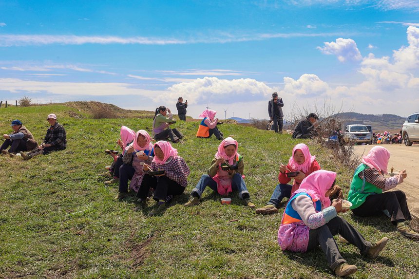 務工群眾在威寧自治縣雪山鎮大發村畫眉梁子馬鈴薯種植基地吃午飯。