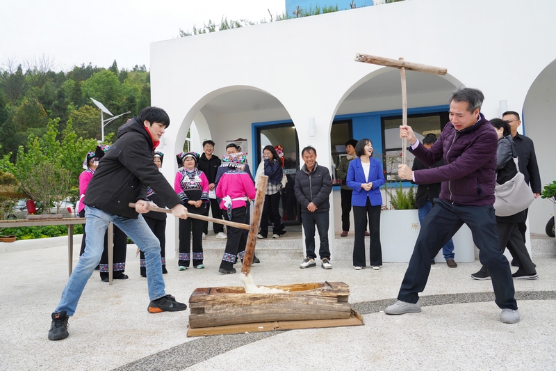 梁志賢（左一）在體驗藍(lán)白小寨體驗打糍粑。