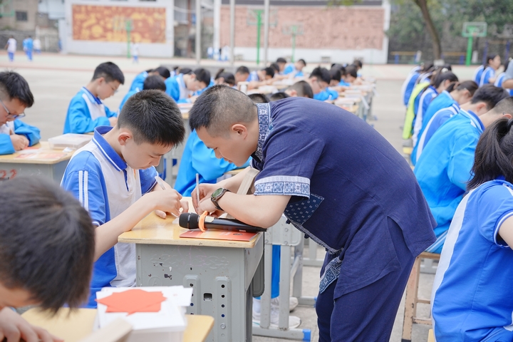 傳承人指導學生剪紙（周鵬飛  供圖）.JPG