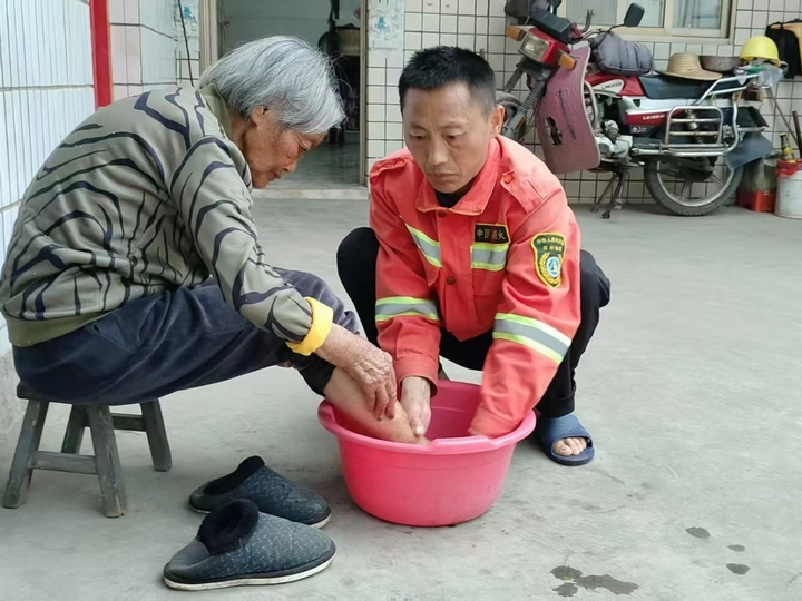 馮再華為母親洗腳。王蕓 攝.jpg