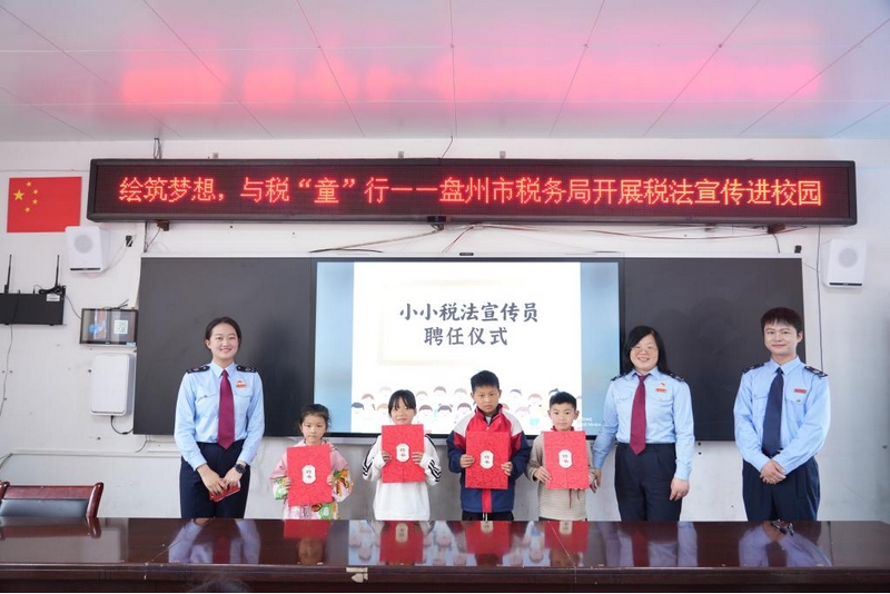 稅務干部為同學們頒發“小小稅法宣傳員”聘書。李琪攝
