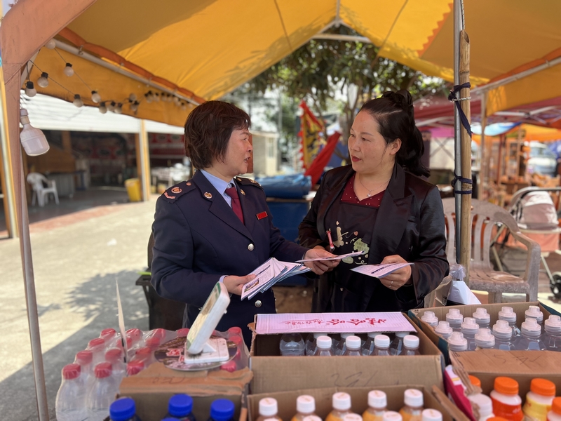 丹寨縣稅務局稅務干部向景區商戶開展稅收普法，引導其合規經營。吳珊珊攝