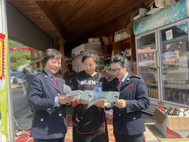 丹寨縣稅務局稅務干部向景區商戶開展稅收普法，引導其合規經營。吳珊珊攝