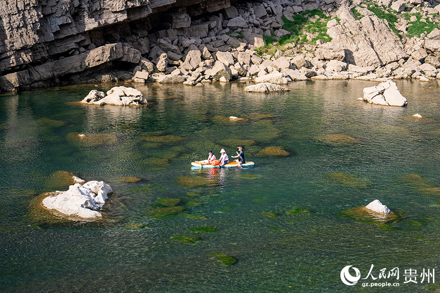 游客在清澈的河水中感受自然的樂趣。人民網記者 涂敏攝
