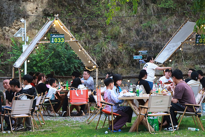 5、游客夜晚圍坐篝火旁，品嘗燒烤、仰望星空，沉浸于“時光音樂會”的民謠彈唱中。王琨榮攝