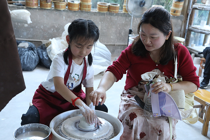 家長帶著孩子體驗當地瑤陶文化。