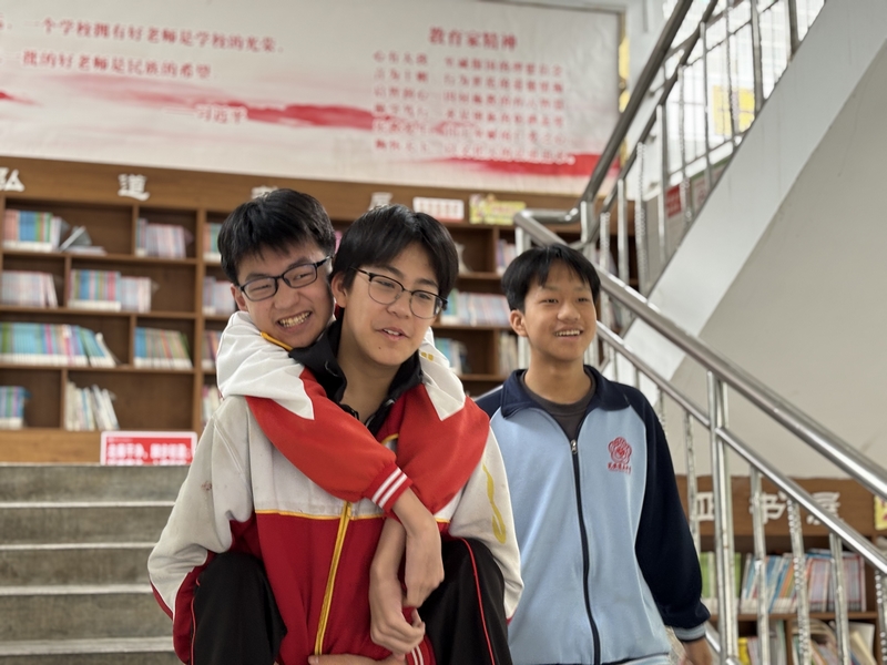 陳璟天背著方證淇走在路上，羅順洋陪在一旁。肖年童攝