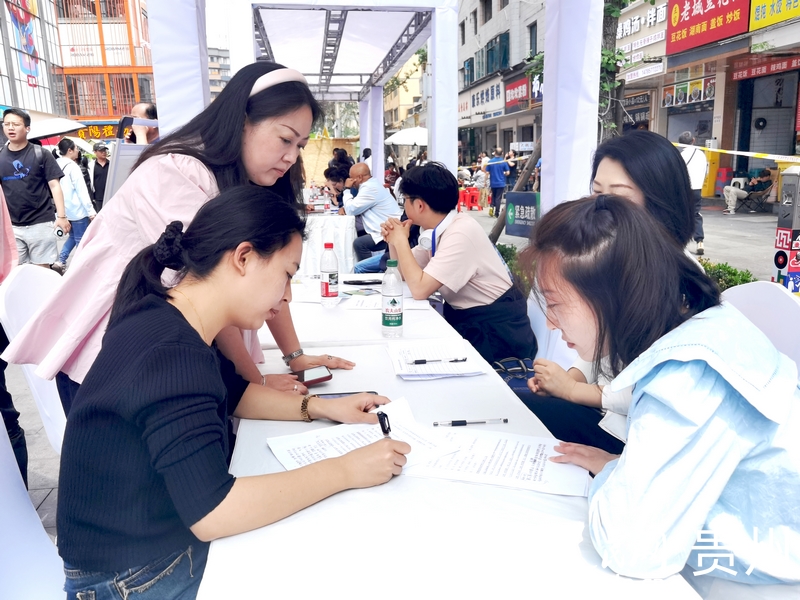 在青云市集的招聘攤位前，求職人員正在填寫信息。人民網記者 王秀芳攝