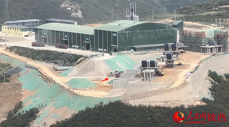 廠區內,一輛鏟車(箭頭所指處)正在進行裝車作業(攝于5月16日)。