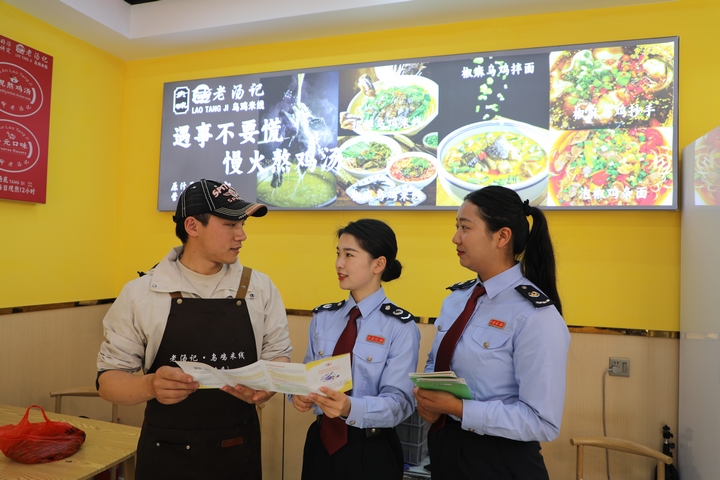 4 圖為普安縣稅務局“文旅服務專班”到景區(qū)周邊商超、餐飲等個體工商戶征詢涉稅服務需求，宣傳稅收優(yōu)惠政策。張杉 攝.JPG