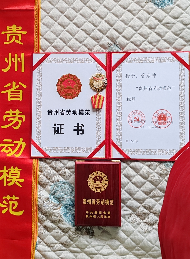 管彥坤榮獲全省勞模的榮譽證書和獎章。