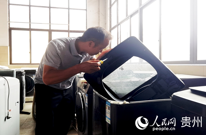 黎以明正在檢修剛回收來的洗衣機。人民網(wǎng)記者 王秀芳攝