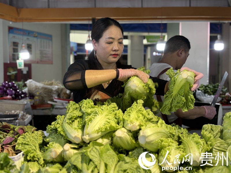 羅芬正在整理攤位上的蔬菜。人民網(wǎng)記者 高華攝