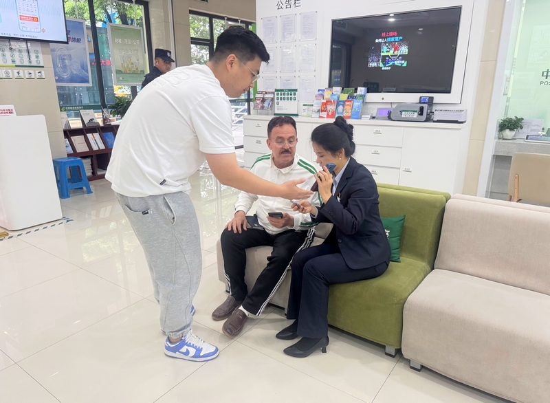 郵儲銀行黔東南州分行營業(yè)部業(yè)務(wù)人員借助中英文轉(zhuǎn)換APP與外籍客戶交流。