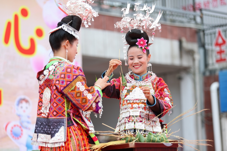 2025年5月29日，在貴州省丹寨縣金泉街道，身著傳統服飾的搬遷群眾在參加包粽子比賽。