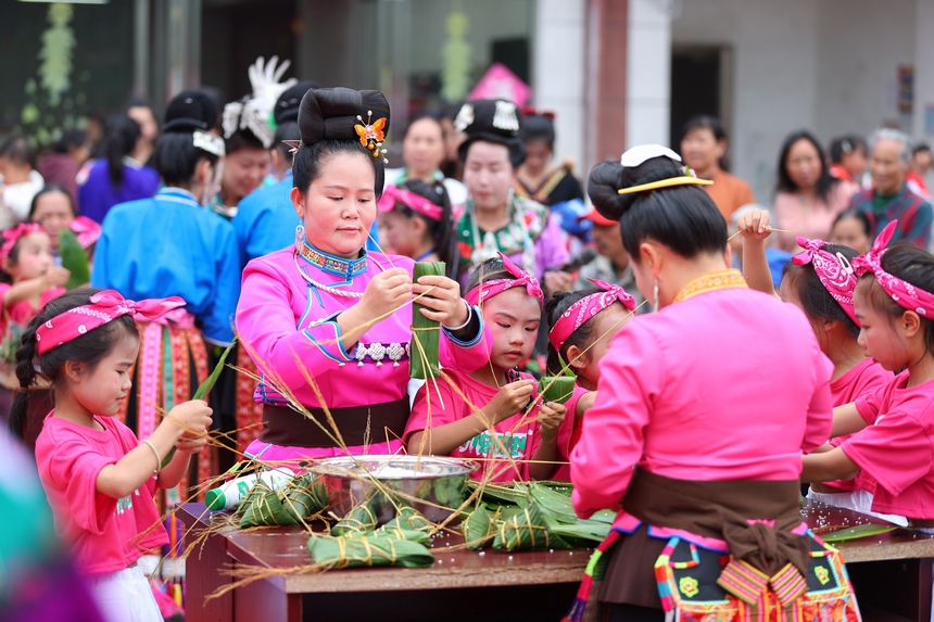 2025年5月29日，在貴州省丹寨縣金泉街道，身著傳統(tǒng)服飾的搬遷群眾在參加包粽子比賽。