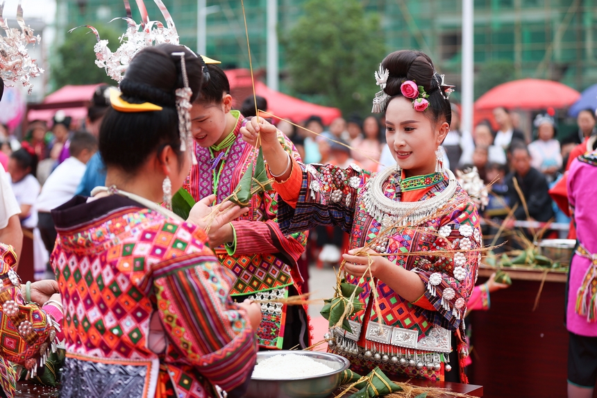 2025年5月29日，在貴州省丹寨縣金泉街道，身著傳統服飾的搬遷群眾在參加包粽子比賽。
