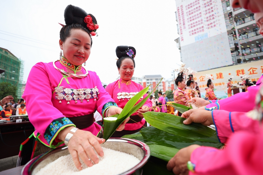 2025年5月29日，在貴州省丹寨縣金泉街道，身著傳統(tǒng)服飾的搬遷群眾在參加包粽子比賽。