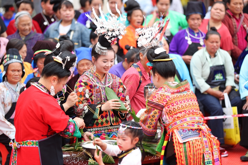 2025年5月29日，在貴州省丹寨縣金泉街道，身著傳統服飾的搬遷群眾在參加包粽子比賽。